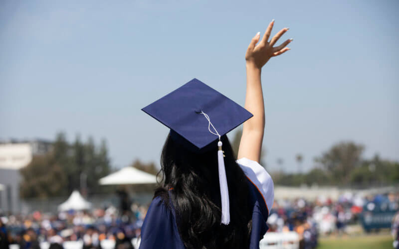 CSUF Commencement Graduate waving towards Crowd