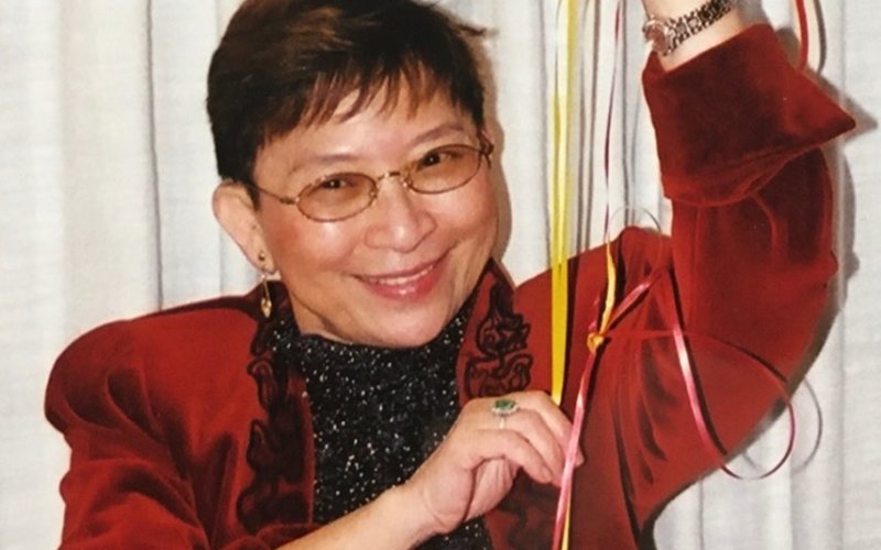 Photo of Veronica T. Chiang, smiling and holding a balloon.