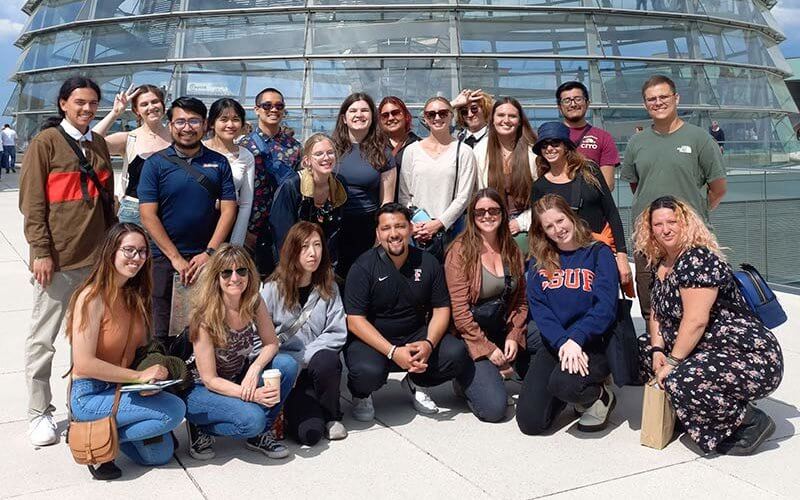 A group of students gathered outside of a dome shaped building.