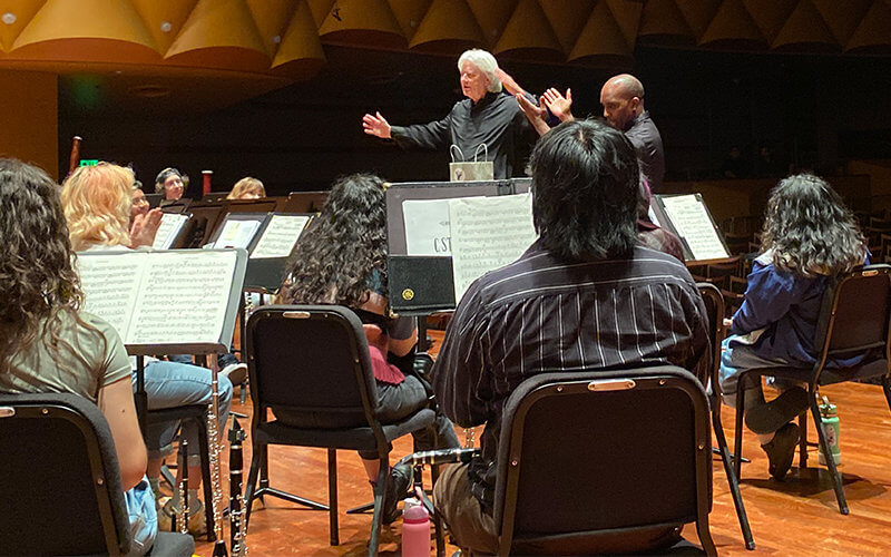 Pacific Symphony conductor Carl St.Clair (left) and conductor Dr. Gregory Xavier Whitmore (right) in rehearsal with University Symphonic Winds.