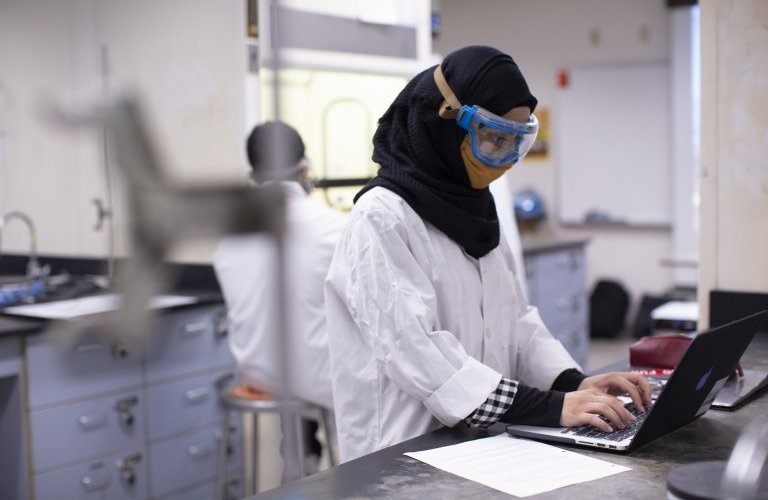 Senior Ayat Garawi taking notes on her research project in her chemistry lab. Photo by Matt Gush