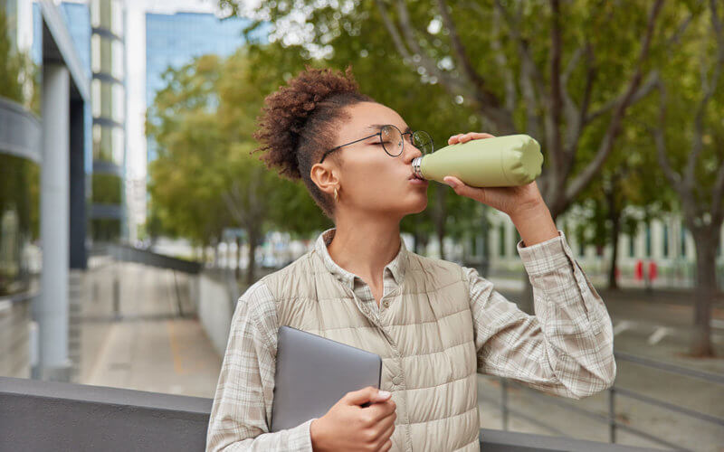 Women drinks from water bottle