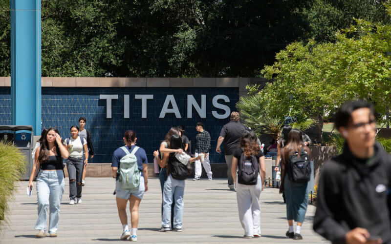 Students walk in front of TITANS sign