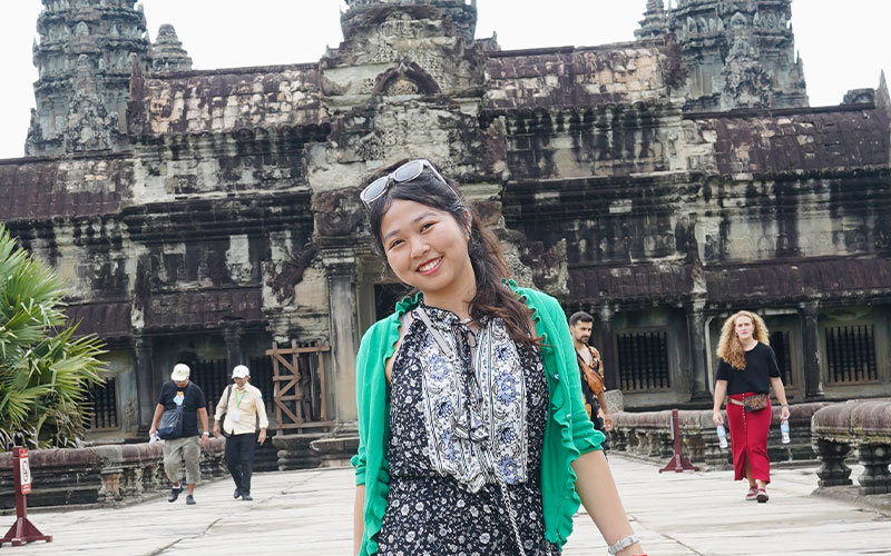 Lyda Im posing for a picture in front of Angkor Wat temple in Cambodia.