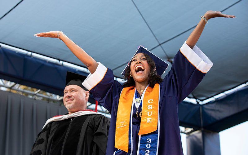 Female student wearing graduation regalia at the Cal State Fullerton commencement ceremony.