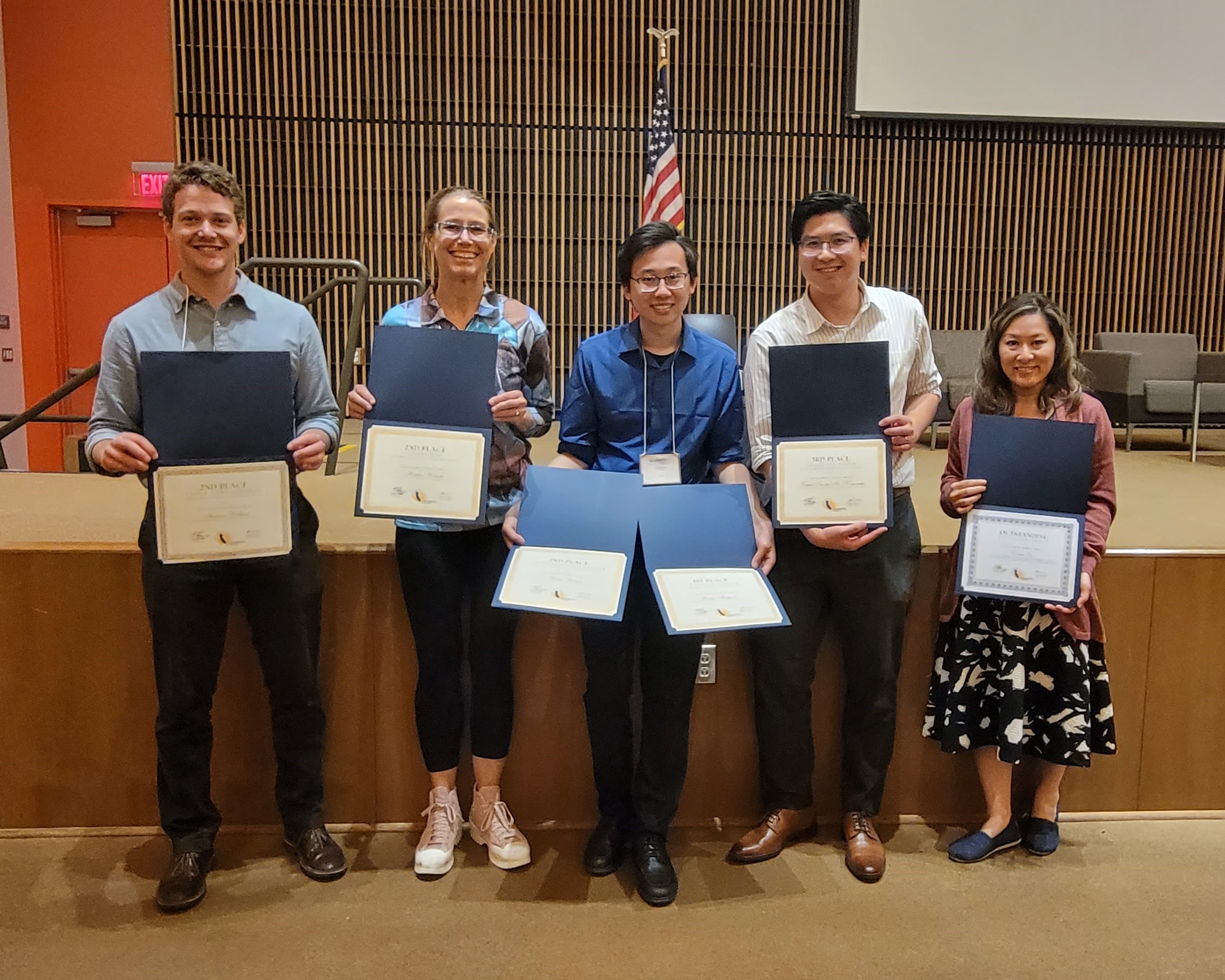 students and faculty holding award certificates