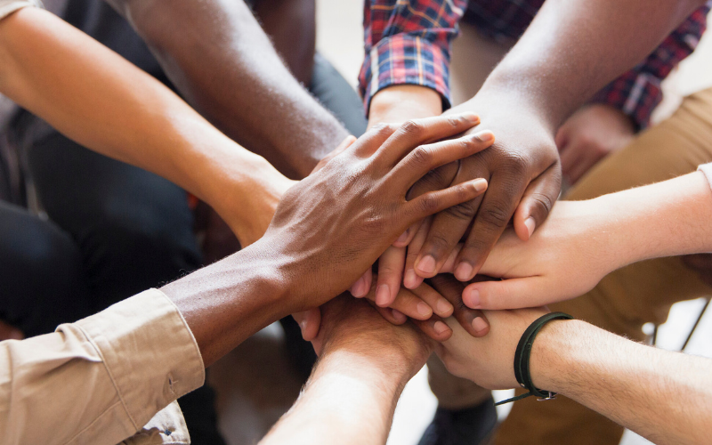 Individuals from all walks of life join hands in a circle