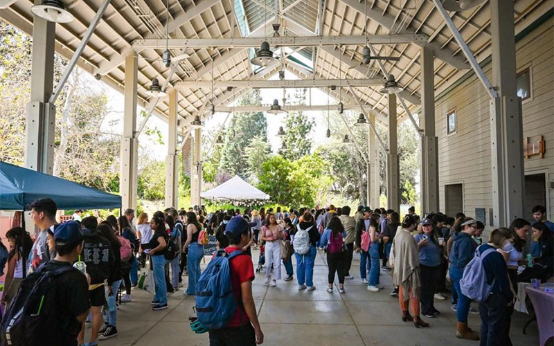 Bacon pavilion at the Arboretum. There is a large crowd of people exploring various vendor booths.