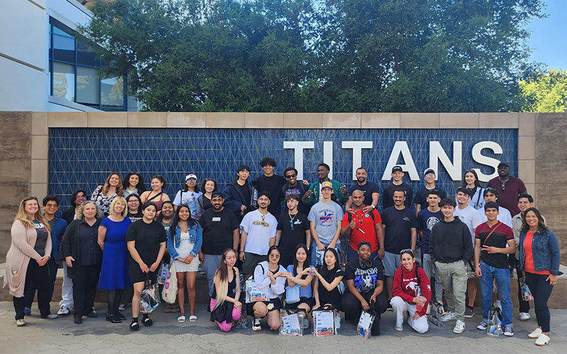 Group photo of Mesa Community College students in front of the TITANS fountain outside Pollak Library.
