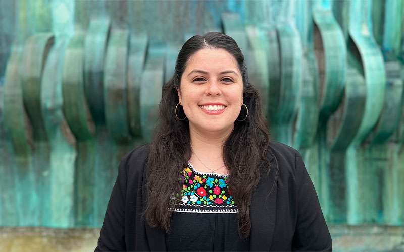 Professional headshot of Abigail Segura, standing in front of the fountain at the Cal State Fullerton College of the Arts.