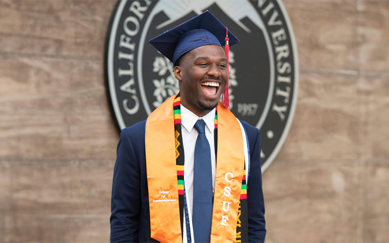 Erwin Amouzou Ametodji wearing CSUF graduation regalia.