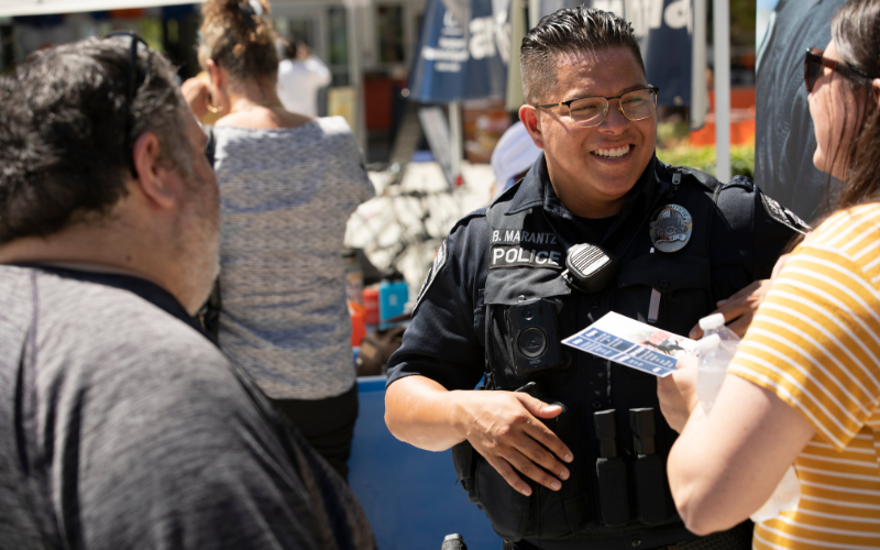 Officer Marantz in uniform speaking with community members