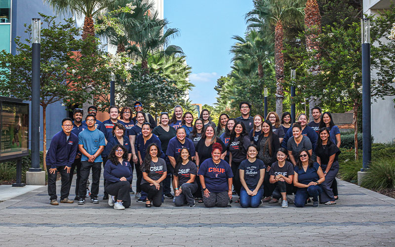 Group photo of the Extension team on Titan Walk wearing CSUF t-shirts.