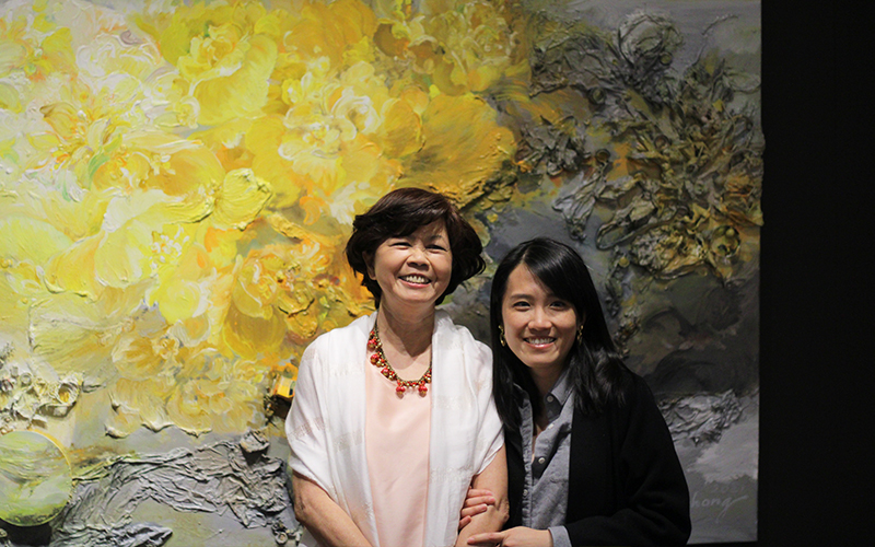 Artist Ann Phong (left) and gallery guest near one of her paintings.