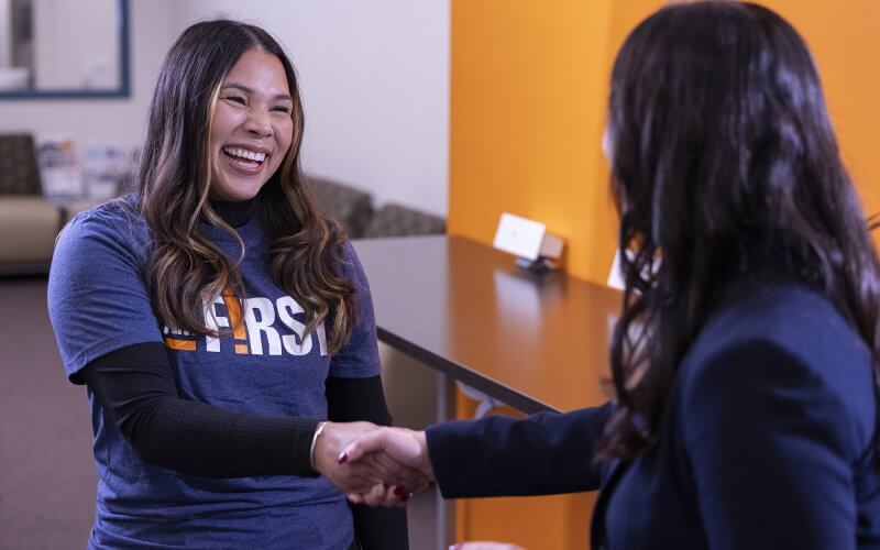 Lizeth Fuentes shakes hand with Elizabeth Zavala