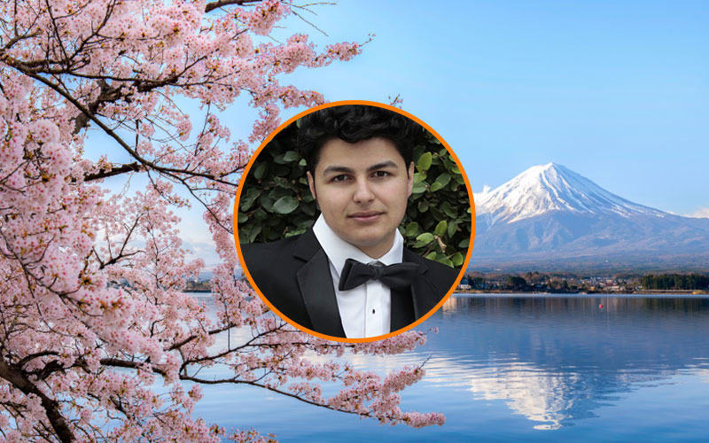 Circular image frame outlined in orange with a headshot of Joseph Ortiz. Behind the frame is an image of Mount Fuji and cherry blossom trees in Tokyo.