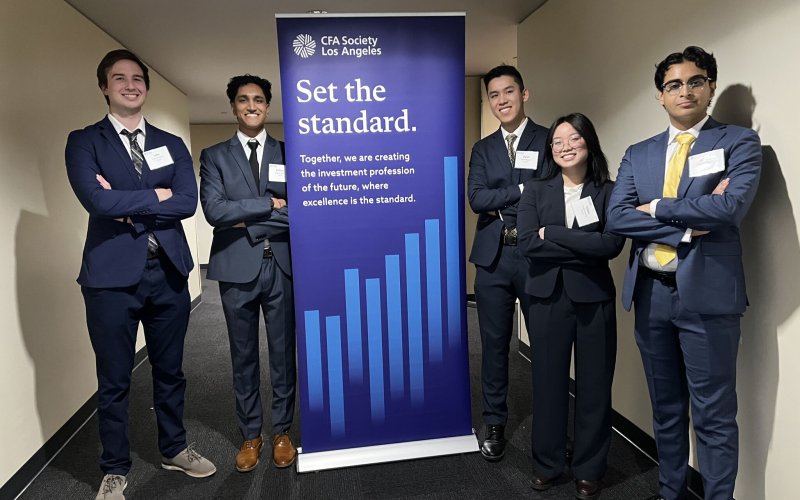 Five Titan Capital Management students pose in front of a banner for the 2025 CFA Institute Research Challenge Los Angeles local competition.