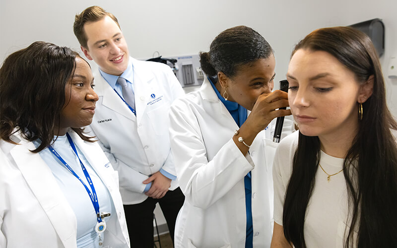 Ross University students check on a patient