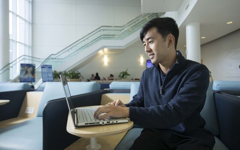 Dylan Ohashi, aspiring public accountant, works on laptop