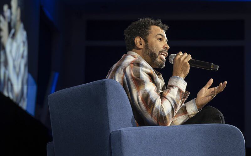 "Hamilton" star Daveed Diggs sits in a chair and speaks into a microphone at CSUF's Feb. 20 Beyond the Conversation event.