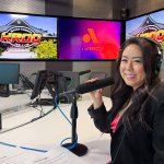 Tara Suwinyattichaiporn, CSUF associate professor of human communication studies, sits at a table with a microphone and headset at the KROQ-FM studio.