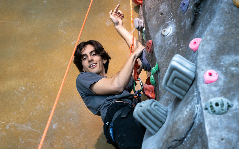 A Cal State Fullerton student climbs the rock wall in the Student Recreation Center