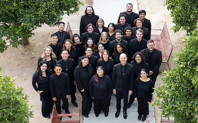 A group of University Singers standing in an orange grove