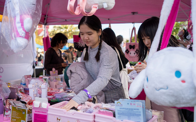 Two Cal State Fullerton students browse through a vendor's shop at ASI's Tuffy's Marketplace in 2024.