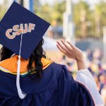 A CSUF graduate waves to the crowd.