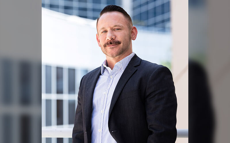 Shaun Pichler, CSUS management teacher, is held outside the College of Business and Economics.