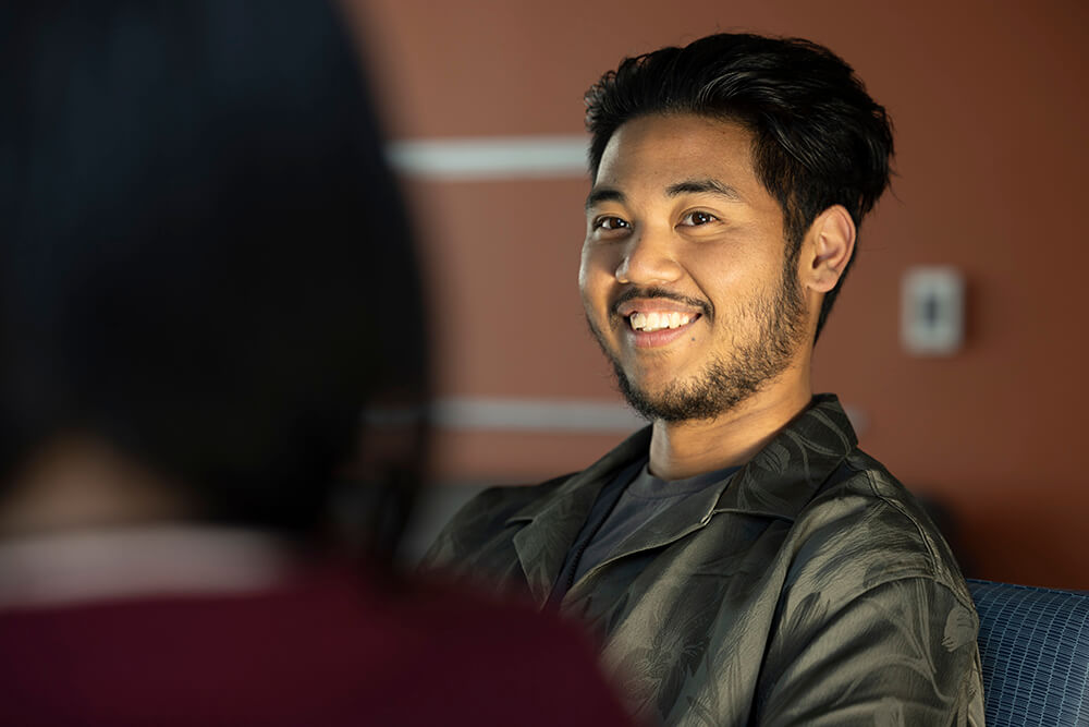 Jovin Justice Adamos speaks to a student in CSUF's Housing and Residential Engagement.