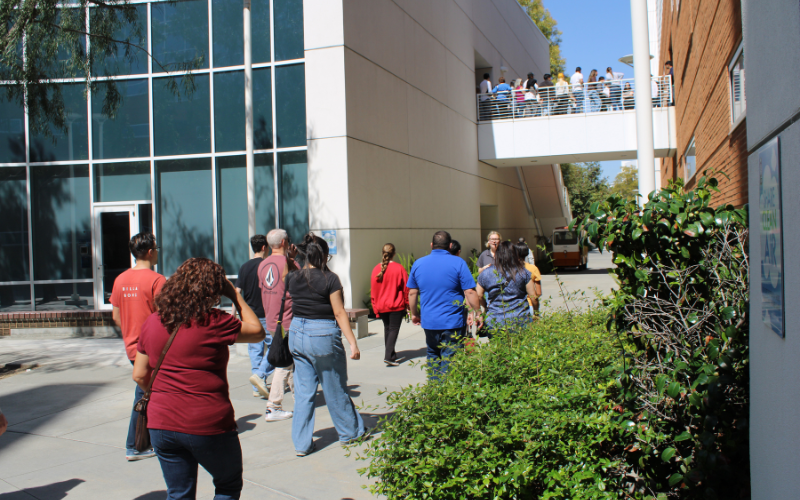 A student visits a group of people at Mihaylo Hall.