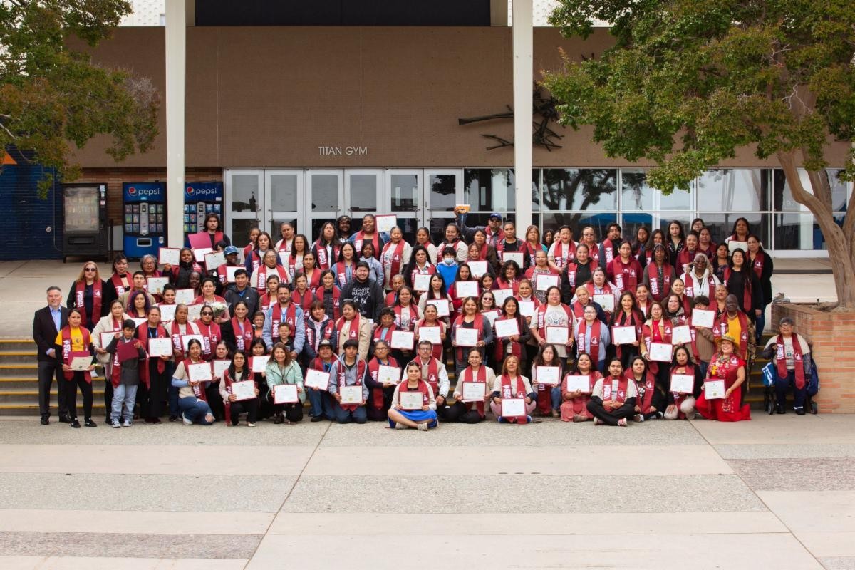 Graduating students from LA Partnership pose for a group photo outside of Titan Gym.