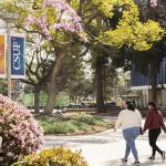 Students walking on pathway in front of the humanities building.