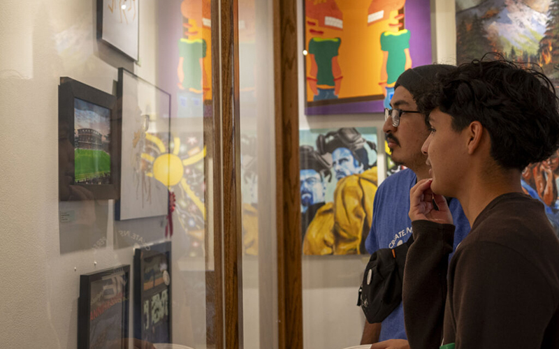 Two students view artwork on display at the Titan Student Union Center Gallery.