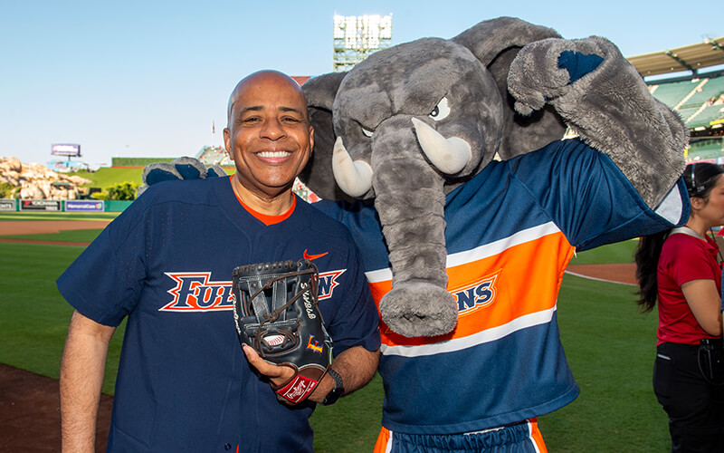 CSUF President Ronald Rochon and Tuffy pose for a photo on the field at Angel Stadium.