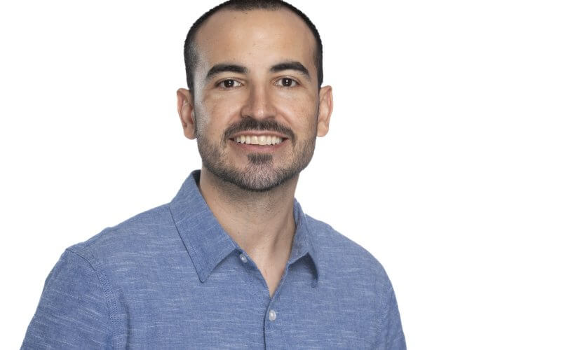 Portrait of mathematics faculty member Matheus Guerrero in a blue shirt in front of a white background