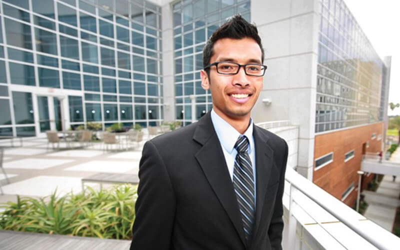 Student stands outside the CSUF College of Business and Economics.