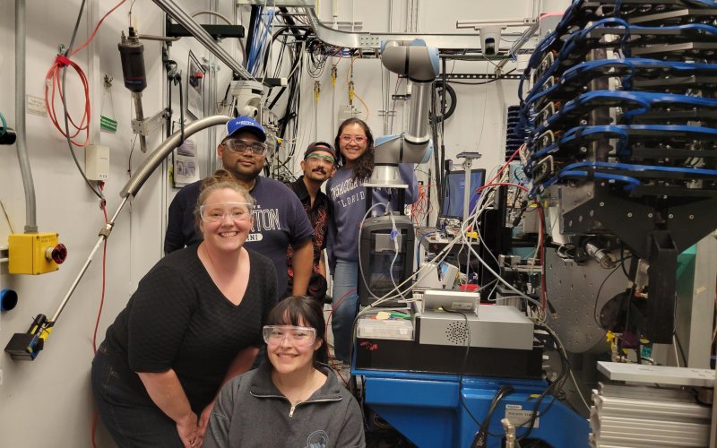 Marissa Figeroa, Allyson Fry-Petit, Linh Kim, Niko Clark, and Ashley Godoy stand next to the 11-BM X-ray diffractometer at the Advanced Photon Source.