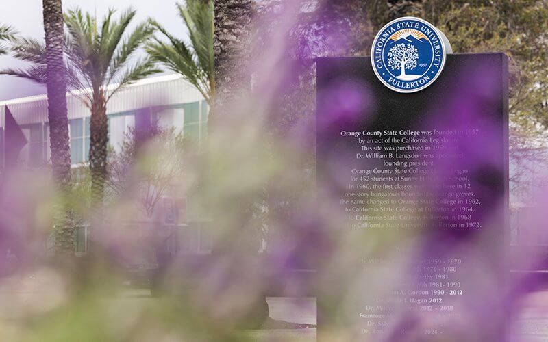 Flower framed view of the black granite monument with CSUF seal.