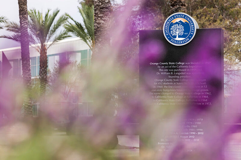 Flower framed view of the black granite monument with CSUF seal.
