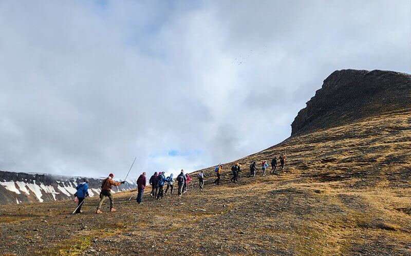 A group of college students hike up a slope in Svalbard.