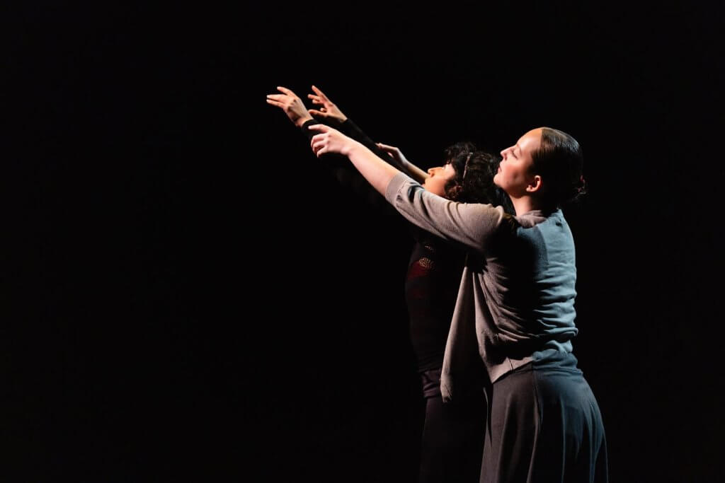 Dancers perform on stage. 