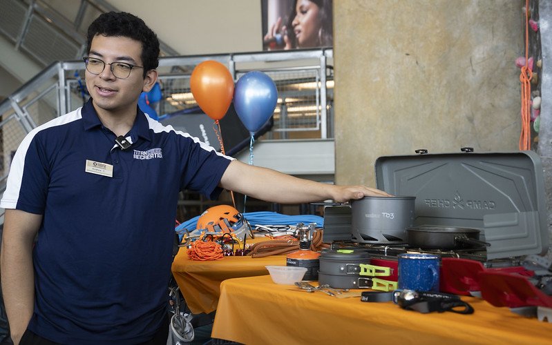 A Titan Outdoors staff member showcases equipment available at the rental center.