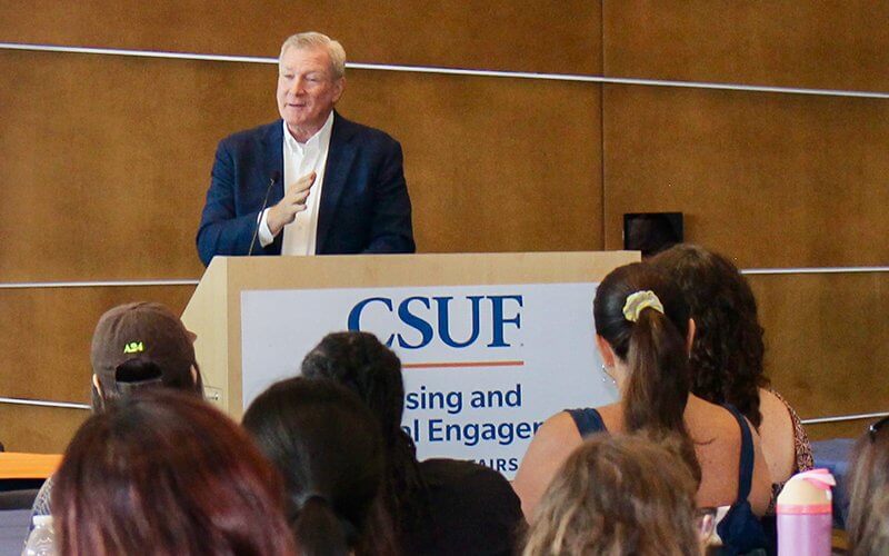 CSUF alum Tom Mehrmann speaks to a group of students.