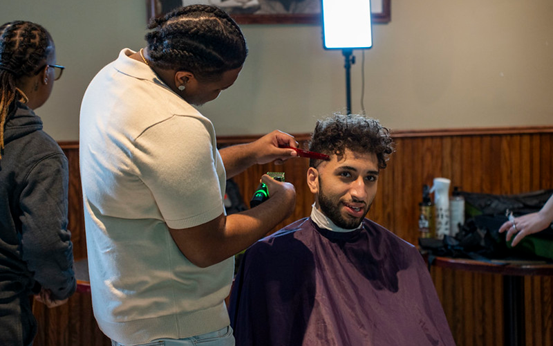 A student receives a free haircut during a "Barbershop Talks" event in the Titan Student Union Pub.