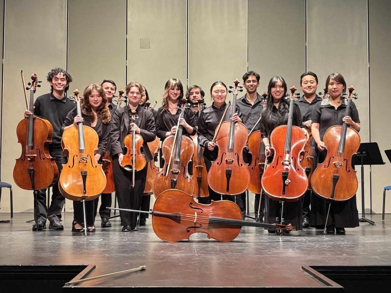 Cello students pose for a photo on stage in Germany.