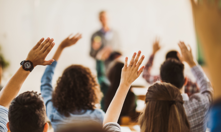 People raise their hands during a lecture.