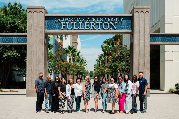 A group of faculty smile in front of the CSUF Promenade.