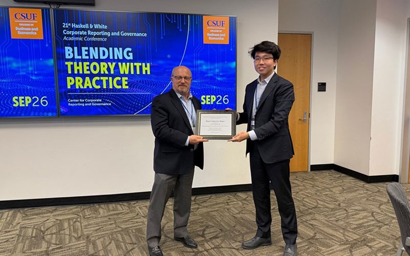 Wayne Pinel entrega el premio al mejor artículo a un miembro del cuerpo docente de la Universidad Purdue.